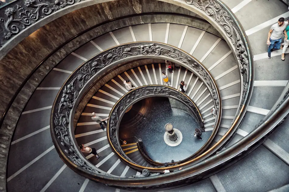 Spiral stair composition in Rome with people moving through the frame.